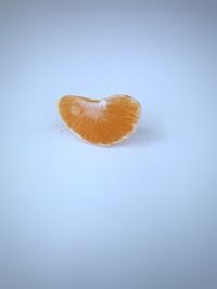 Close-up of orange slice over white background