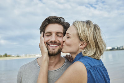 Happy young couple kissing on the beach