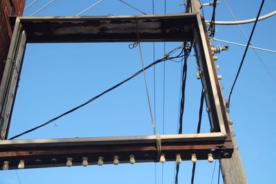 Low angle view of suspension bridge against clear blue sky