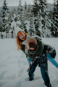 Portrait of smiling woman on snow covered field