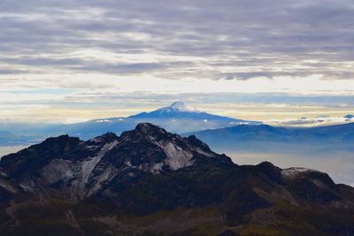 Scenic view of mountains against cloudy sky