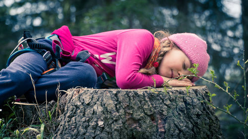 Close-up of girl sleeping on tree stump