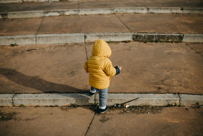 Rear view of baby boy walking on steps