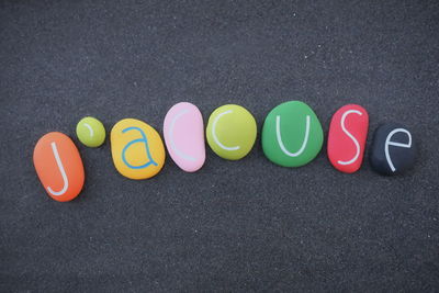 J'accuse, french word meaning i accuse text composed with multi colored and carved stone letters 