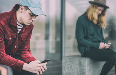 Young woman looking away while using mobile phone