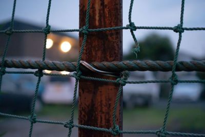 Close-up of rope tied to metal fence