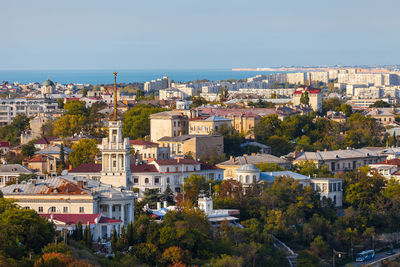 High angle view of town by sea against clear sky