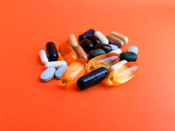 Close-up of colored pencils over orange background