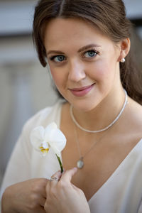 Close-up of young woman holding flower