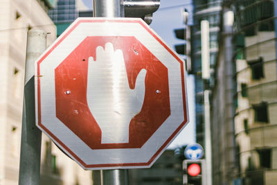 Close-up of arrow sign on road in city