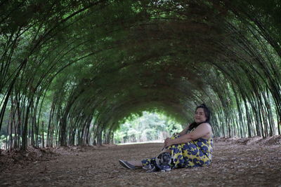 Portrait of woman with pug sitting on land