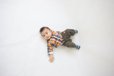 Portrait of cute boy playing in white background