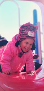 Portrait of cheerful girl on slide at playground