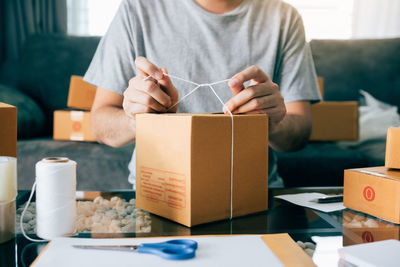 Midsection of man holding paper in box