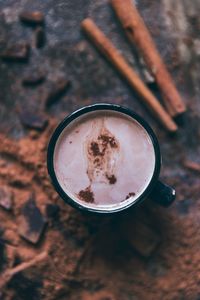 High angle view of coffee cup with cinnamons on table