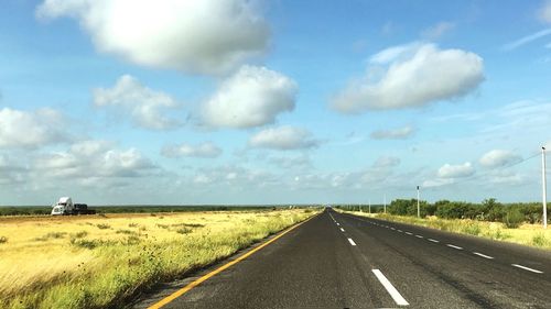 Road by landscape against sky