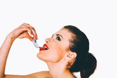 Close-up portrait of woman with hand against white background