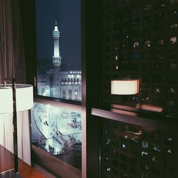 Illuminated building seen through glass window at night