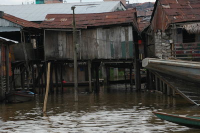 Boats in river by houses against buildings