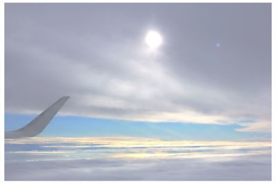 Cropped image of airplane flying over clouds