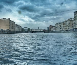 River in city against cloudy sky