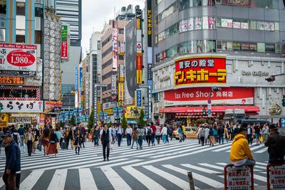 Crowded people are walking and shopping at a street in shinjuku town.