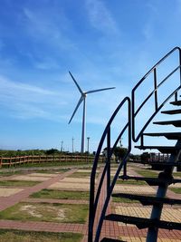 Wind turbines on field against sky