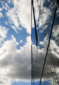 Low angle view of sailboat against cloudy sky