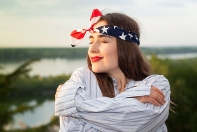 Close-up of beautiful woman wearing bandana against sky