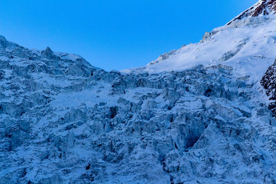 Scenic view of snowcapped mountains against clear blue sky