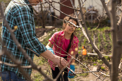 Girl with grandfather cutting trees