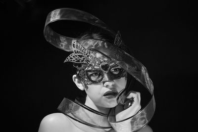 Portrait of boy wearing mask against black background