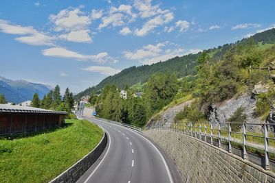 Road amidst trees against sky