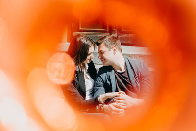 Portrait of couple kissing on orange flower