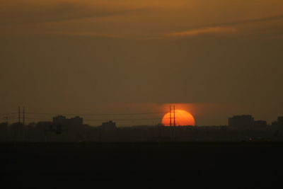 Scenic view of silhouette field against sky during sunset