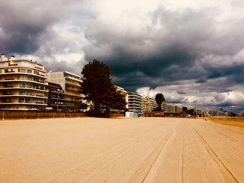 View of city buildings against cloudy sky
