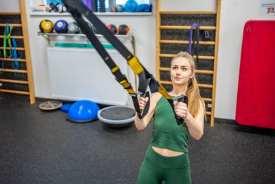 Portrait of young woman exercising in gym