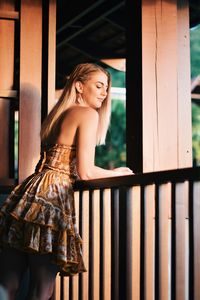 Young woman standing by railing