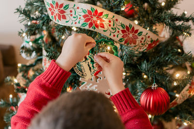 Young boy hanging decorations on a christmas tree