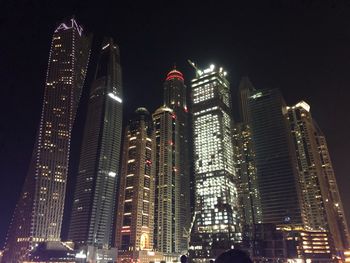 Low angle view of illuminated buildings against sky at night