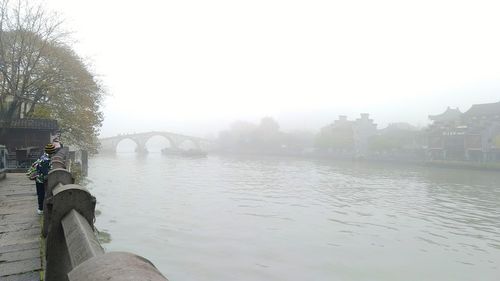 Scenic view of river against sky during foggy weather