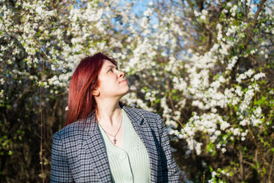 Young woman standing against trees