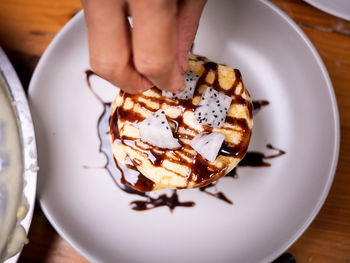 Midsection of person holding ice cream in plate