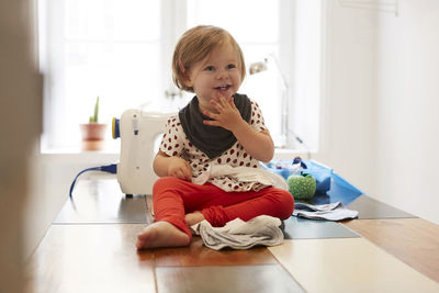 Full length of girl wearing scarf while sitting on table at home