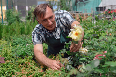 Smiling gardener working at greenhouse