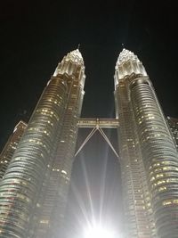 Low angle view of illuminated buildings against sky at night