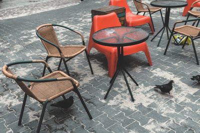 High angle view of empty chairs and table at sidewalk cafe