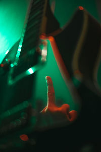 Low section of woman standing by illuminated light