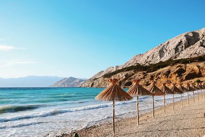 Scenic view of beach against clear blue sky