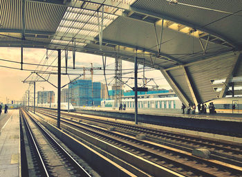 Railroad station platform in city against sky